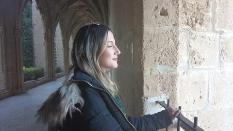 Young lady watches the view from inside the stone building. Stock Footage 232637941