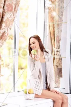 Young lady on the windowsill with seasonal fruits Stock Photos