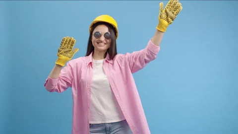 Young lady worker in yellow hard hat, american glasses and gloves Video stock 240940944