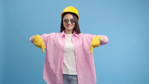 Young lady worker in yellow hard hat, american glasses and gloves Video stock 243738093