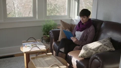 Young lady working on a computer tablet in a wide tracking shot Stock Footage 70809297