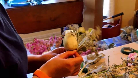 A young lady's hands are working on flower arrangements at home for a wedding Vídeo Stock 153113855