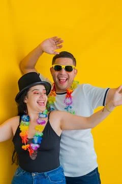 Young latin couple, dancing while laughing loudly, he's behind her. yellow .. Stock Photos
