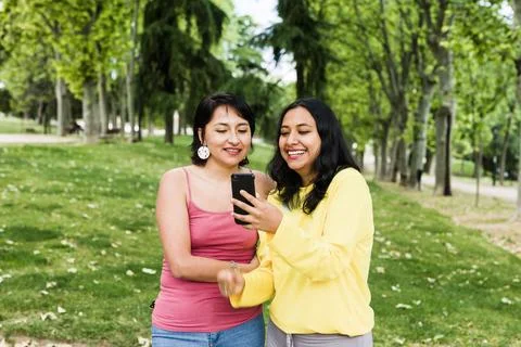 Young latin female in a video call with a smartphone with friends cause social Stock Photos