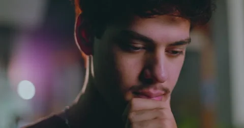 Young Latin Hispanic man in deep thought, hand on chin, looking down with pensiv Видео 311431083