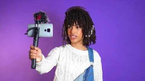 Young latin influencer recording content with smartphone and microphone Stock Footage 301369736
