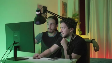 Young Latin man explaining something to his co-worker on the desktop comput.. Stock Footage 237615623