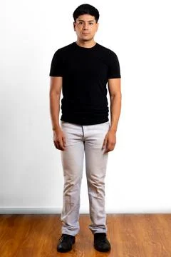 Young Latin man pose for full length vertical portrait looking at the camera Stock Photos