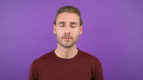 Young latin man taking a break and relaxing with closed eyes isolated on purple Stock Footage 148275815