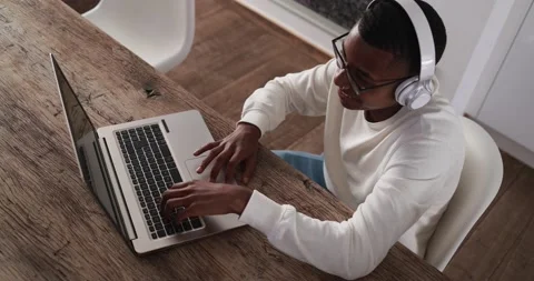 Young latin man typing on computer laptop while wearing headphones Video stock 151680269