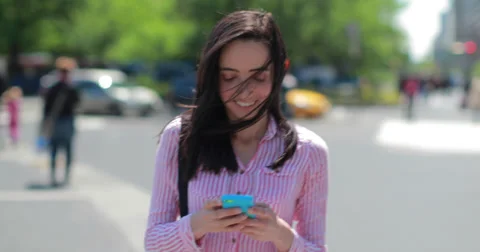 Young Latina Hispanic woman in city walking texting smart phone cellphone Stock Footage