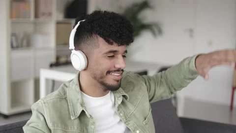 Young latino man dancing while listening music with headphones at home Stock Footage 172506358