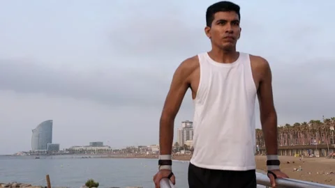 Young latino man exercising dips in an outdoors calisthenics park Stock Footage 256431330