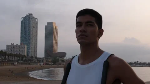 Young latino man looking at camera after jumping the rope by the beach Stock Footage 256443210