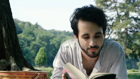 Young Latino Man Reads in the Park Slow Motion Stock Footage