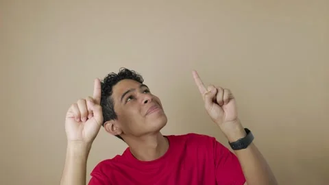 Young Latino man smiling while pointing with his index fingers at a copy sp.. Stock Footage 315237646