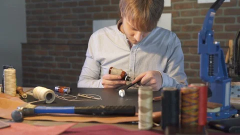 Young leather craftsman creates a DIY product. Craftsmanship workman. Men hobby. Vidéo 130147172