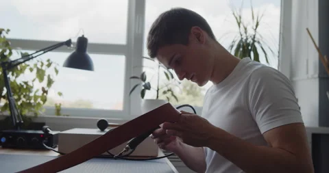 Young leather worker examining leather belt during manufacturing process Stock Footage 144891436