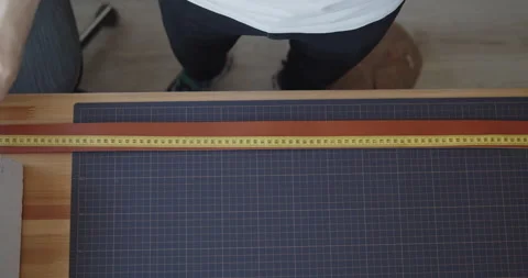 Young leather worker measuring leather strip for making a belt Stock Footage 146131257