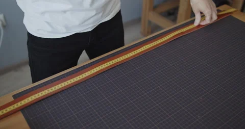 Young leather worker measuring leather strip for making a belt Stock Footage 146131483