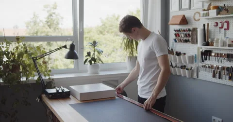 Young leather worker preparing leather blank for making a belt Stock Footage 144888610