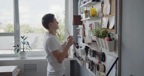 Young leather worker takes tools off a tools wall Stock Footage 144892977