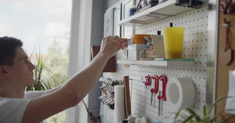 Young leather worker takes tools off a tools wall close-up Stock Footage 146135635