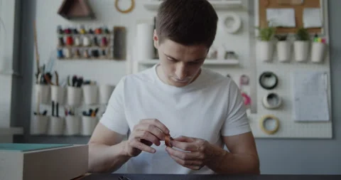 Young leather worker with vitiligo hand stitching a leather loop for a belt Stock Footage 146137801