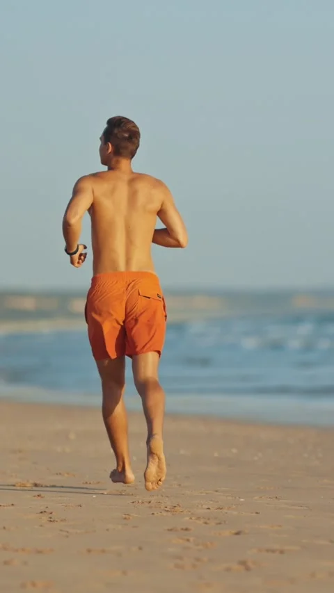 Young lifeguard running on the beach Stock Footage 329136154