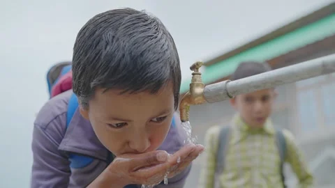 Young little boy drinking clean water from a running tap in a rural village. Stock Footage 161872586