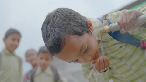 Young little boy drinking clean water from a running tap in a rural village. Vidéo 161872588