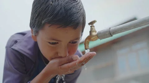 Young little boy drinking clean water from a running tap in a rural village. Vidéo 161872609