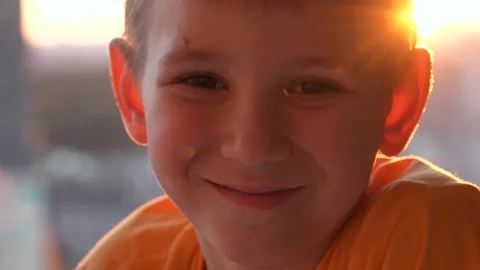 Young little boy smiling looking at camera with sunset background Video stock 325731628