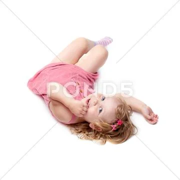 Young little girl lying over isolated white background Stock Photos