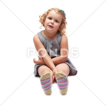 Young little girl sitting over isolated white background Stock Photos