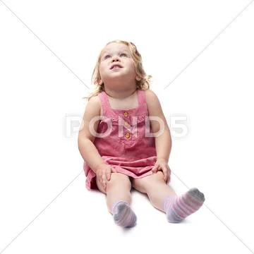 Young little girl sitting over isolated white background Stock Photos