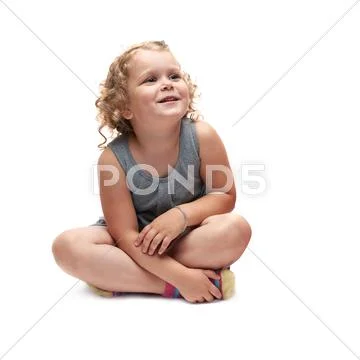 Young little girl sitting over isolated white background Stock Photos