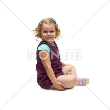 Young little girl sitting over isolated white background Stock Photos