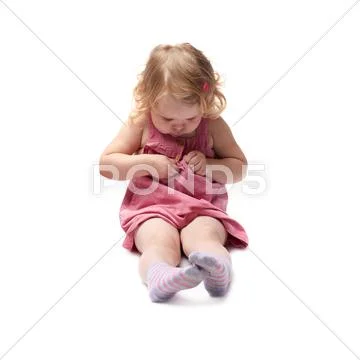 Young little girl sitting over isolated white background Stock Photos