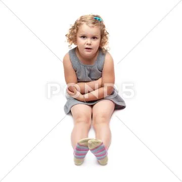 Young little girl sitting over isolated white background Stock Photos