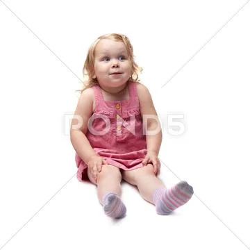 Young little girl sitting over isolated white background Stock Photos