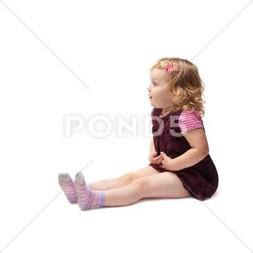Young little girl sitting over isolated white background Stock Photos