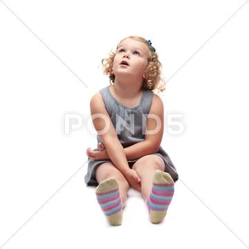 Young little girl sitting over isolated white background Stock Photos