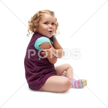 Young little girl sitting over isolated white background Stock Photos