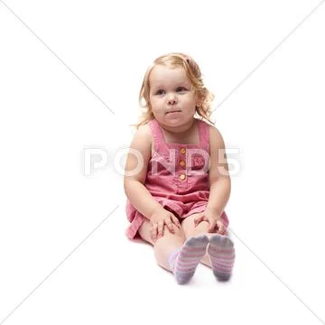 Young little girl sitting over isolated white background Stock Photos