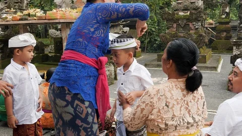 Young local boy receiving accessory at Melukat Mebayuh Ceremonial, Bali Stock Footage 140302371