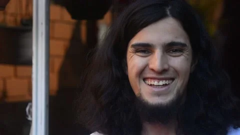 Young long haired and bearded man smiling and laughing natural and spontaneously Stock-Footage 135622807