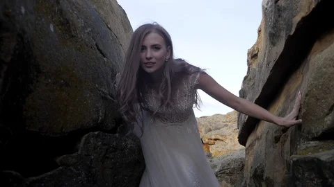 Young long haired bride posing among stones in the sunset Stock Footage 129073026