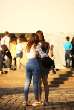 Young long-haired brown-haired girls walk in the center of the ancient city.  Stock Photos