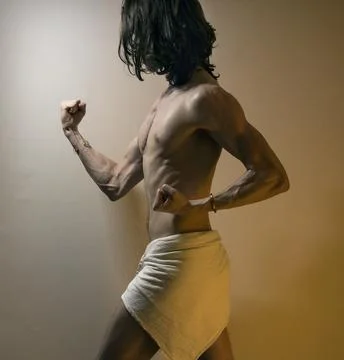Young long haired man standing firmly, warrior pose Stock Photos